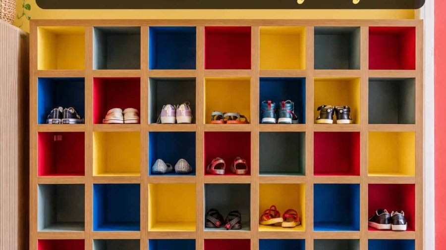 Slim white shoe cabinet in a small entryway beside a front door